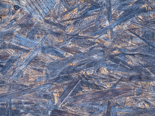 OSB boards are made of brown wood chips sanded into a wooden background.