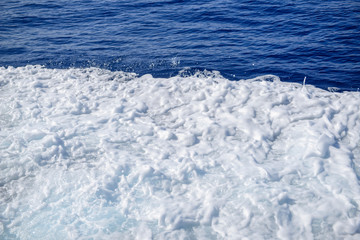 Naklejka na ściany i meble Close-up of sea waves and white foam natural background.