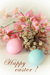pink yellow blue eggs against a background of willow and flowers for the Easter holiday