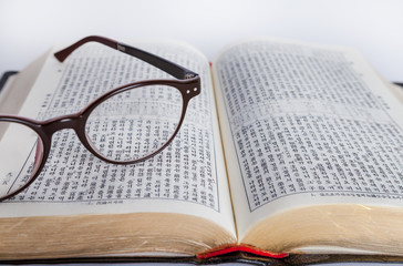 opened bible on the desk with glasses 8