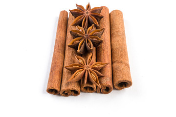 anise stars laying on cinnamon sticks isolated on white background.