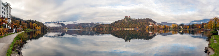 Beautiful autumn landscape around Lake Bled with St. Martin's Parish Church and ships, castle and island