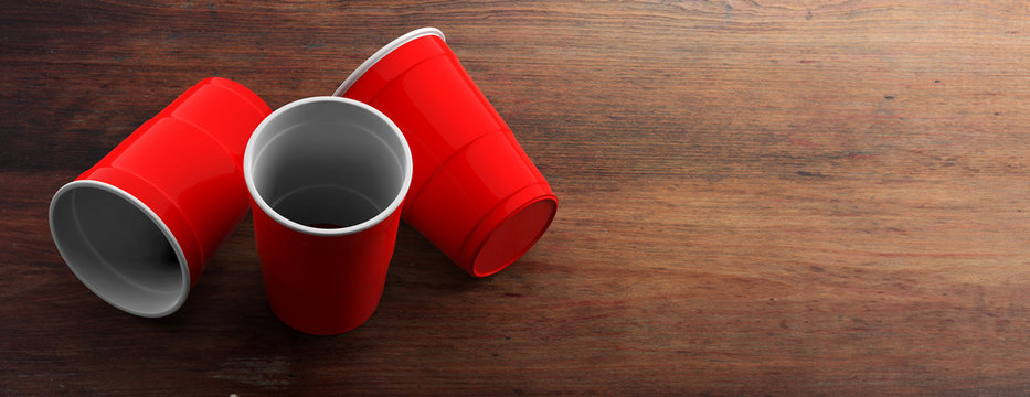 Plastic red color cups on wooden background. 3d illustration