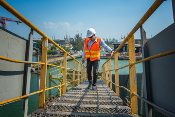 worker, engineering wearing safety shoe with set of safety and security regulation, walking in mind step on the steel checker plate, gangway bridge at workplace, working in high stage & level of insur