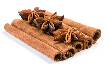 anise stars laying on cinnamon sticks isolated on white background.