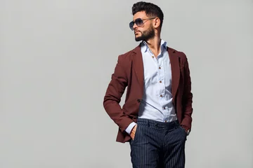 Eleganter junger gutaussehender Mann in der Suite mit Brille. Modeporträt im Studio. © ASjack