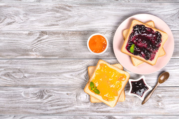Delicious toasts with various sweet jams on grey background. Copyspace for your text, banner.