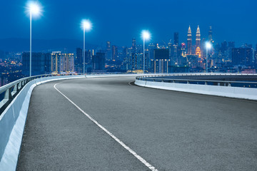 Fototapeta na wymiar High speed corner overpass asphalt road with Kuala Lumpur cityscape , night scene .
