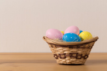 Fototapeta na wymiar Easter eggs in the basket of wooden background.