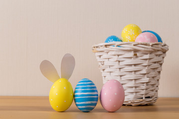 Easter eggs in the basket of wooden background.