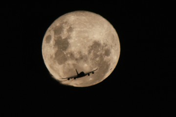 O avião passando em frente a super Lua