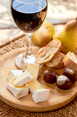 Rustic cheese plate in the interior. brie, pears, walnut, bread, red wine