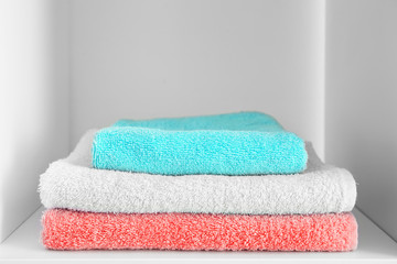 Stack of clean towels on shelf