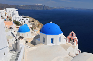 Greek white churchs with blue domes overlooking the sea, Oia, Santorini, Cyclades Islands, Greece.