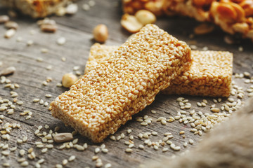 Sesame seed casinos on old vintage background with burlap cloth. Country style. Delicious sweets from seeds of sunflower, sesame and peanuts, covered with shiny glaze