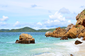Rocks in sea with mountain and cloud