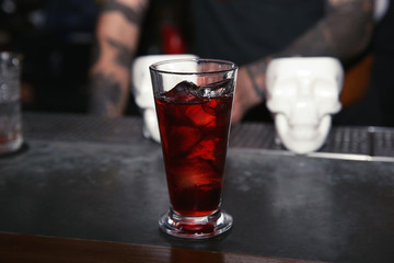 Glass of tasty cocktail on bar counter