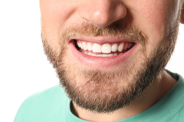 Fototapeta premium Young man with healthy teeth on white background, closeup