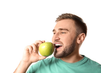 Young man with healthy teeth and apple on white background