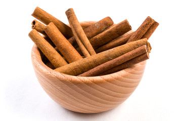 cinnamon sticks  in wooden bowl isolated on white background