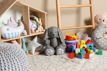 Different child toys on floor against color wall