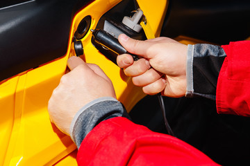 Hands inserts the plug into the 12V socket from the ATV 4wd quad bike cigarette lighter