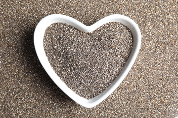 Bowl of chia seeds on grains, top view