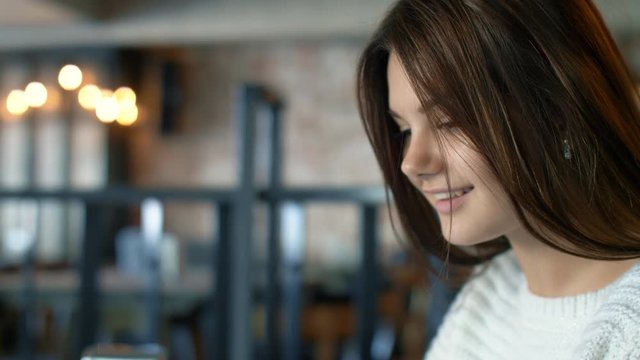 Young nice girl smile in slow motion in cafe. Close up 4k footage.