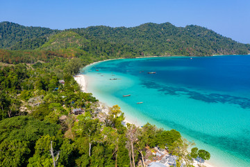 Naklejka premium Aerial drone view of traditional fishing boats moored over a coral reef around a remote, green tropical island in the Mergui Archipelago