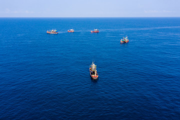 Overfishing - aerial view of a large fleet of fishing trawlers working together in a small area of the Andaman Sea