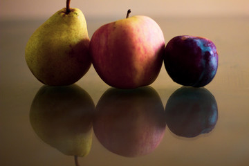Pear, apple and plum. Fresh fruits, different colors and shapes.