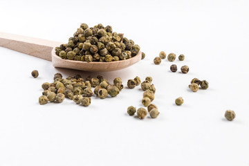 green pepper peppercorns  in wooden spoon isolated on white background.