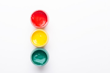 Red, yellow, green gouache on a white background Isolated Paints in containers Top view Traffic light