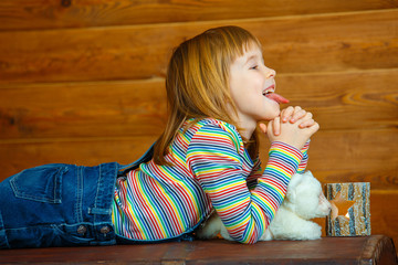 Girl Masha lies on the old chest and shows her tongue.