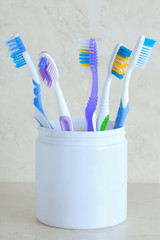 Toothbrushes in white glass. On a marble background. Close-up.