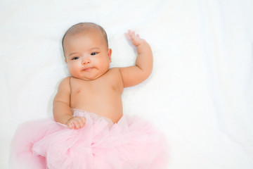 Newborn baby wear pink tutu skirt on white towel background