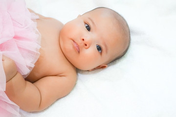 Newborn baby wear pink tutu skirt on white towel background