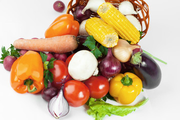mushrooms and a variety of fresh vegetables in a wicker basket.isolated on a white