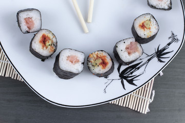 close-up of sushi and chopsticks on a white plate