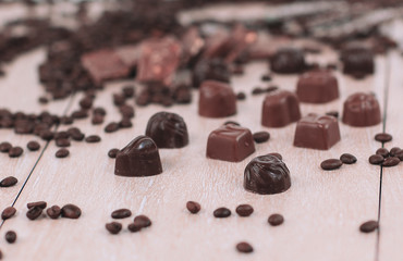 background image of black coffee grain and chocolate candy on wooden background