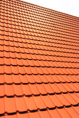Orange concrete roof tiles on a residential home. Roof tiles background texture.