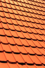 Orange concrete roof tiles on a residential home. Roof tiles background texture.