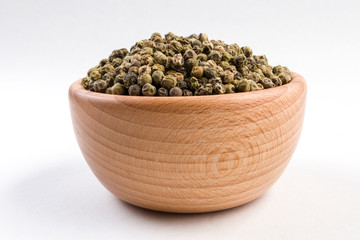 Fototapeta na wymiar green pepper peppercorns in wooden bowl isolated on white background.