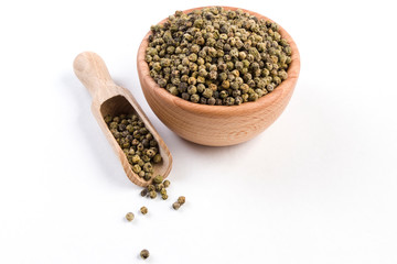 green pepper peppercorns  in wooden bowl and scoop isolated on white background