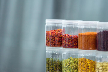 Dried vegetables in glass jars, onions, beets, carrots, pumpkin, bay leaf, banks on blurred background. Superfoods, herbs.