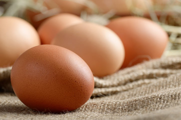Fresh brown organic chicken eggs on wooden table and hemp burlap