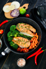 grilled salmon fillet with broccoli and vegetables in a pan