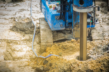 Hydraulic drilling machine is boring holes in the construction site for bored piles work. Bored piles are reinforced concrete elements cast into drilled holes, also known as replacement piles.