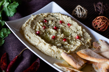 Classic hummus with parsley on the plate and pita bread