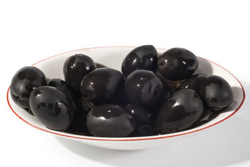 Black olives in a white bowl close up